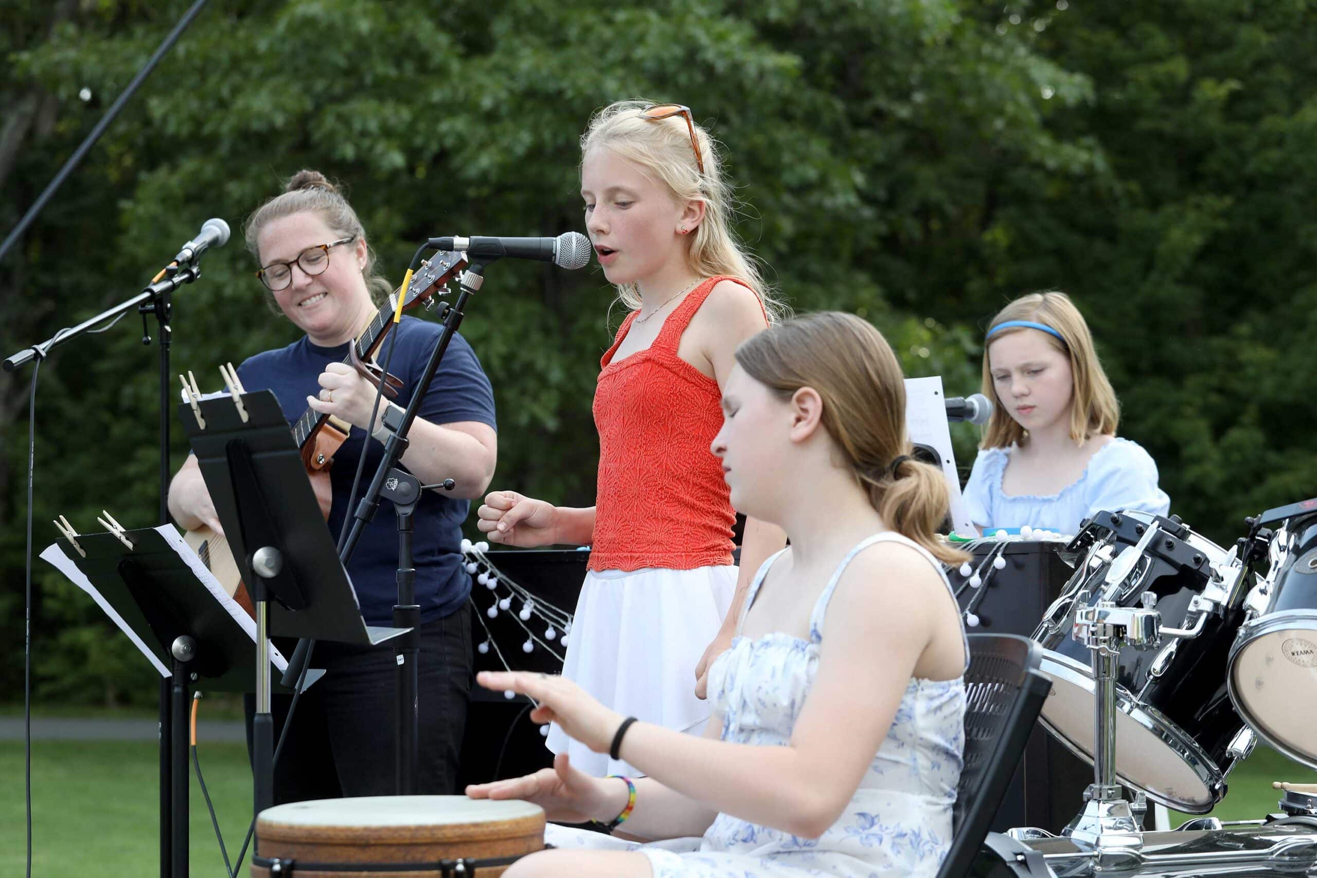 Three student musicians perform with teacher Kassie Bettinelli