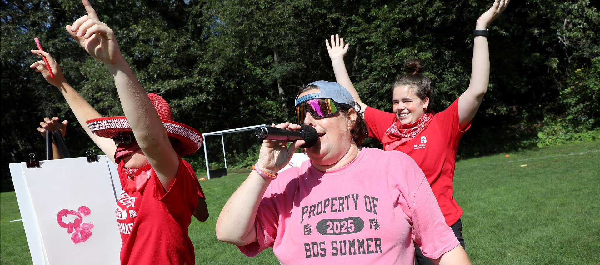 Three camp staff lead morning meeting for campers